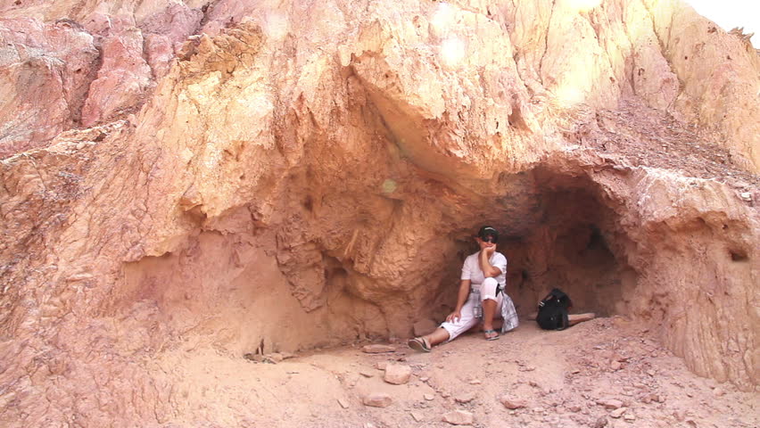High Noon. Two women are hiding from the sun in the shade of rocks and drinking water