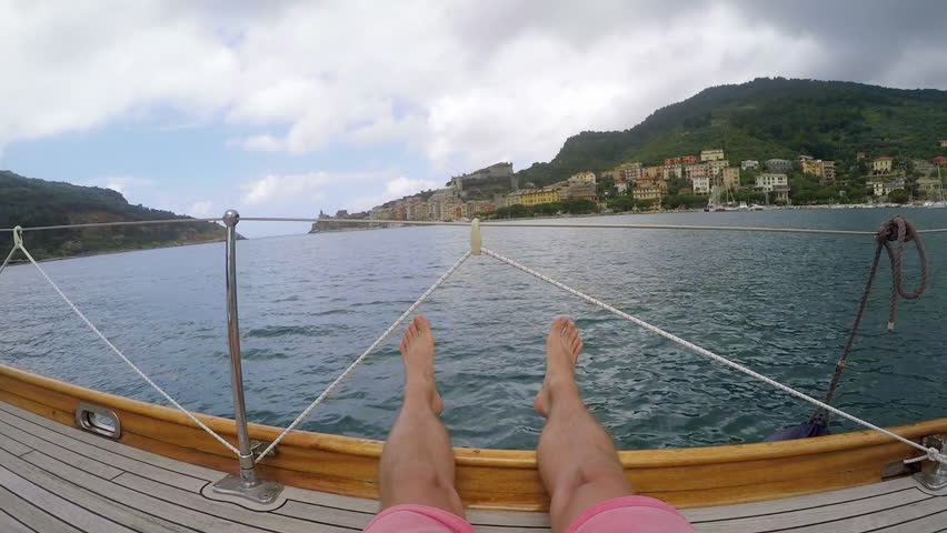 Pov happy man relaxing on deck of wooden sailboat in ocean on travel adventure vacation Gopro