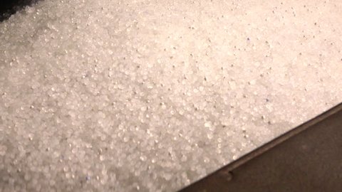 Plastic granules in container of the extrusion equipment. Shot in slow motion