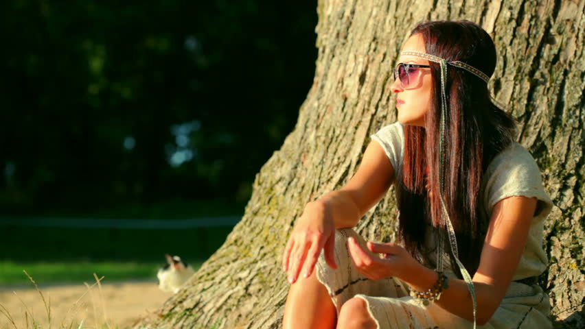 Young girl playing guitar outdoors.	