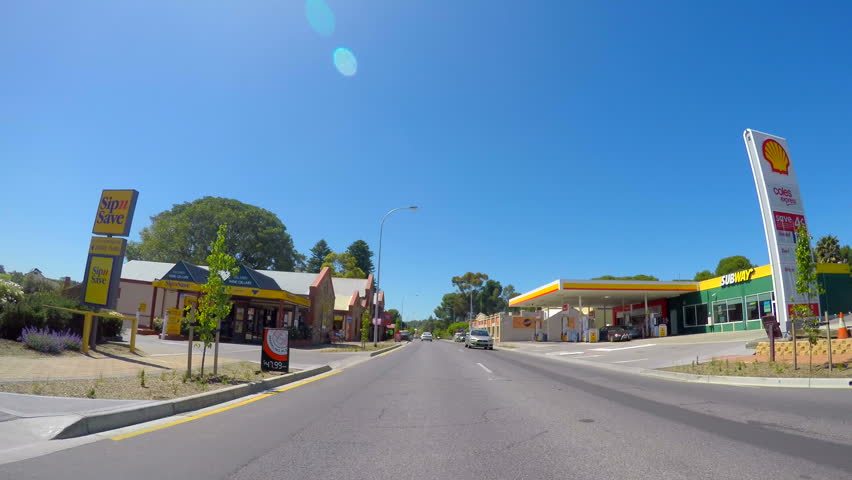 MCLAREN VALE, SOUTH AUSTRALIA - NOVEMBER 5, 2016: Automobile POV driving through the main township of McLaren Vale along Main Road, sunny with lens flare, real time. 