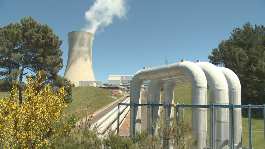 Steam rises from a cooling tower at a geothermal power station where piped in