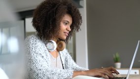 Mixed-race woman working from home on laptop computer