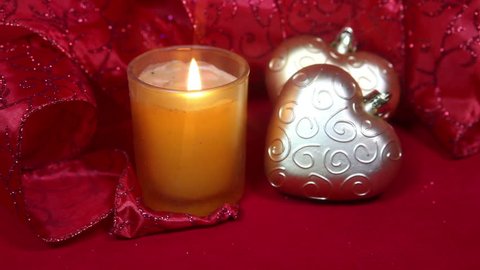 New Year's composition on a red background - ball and ribbon and a candle