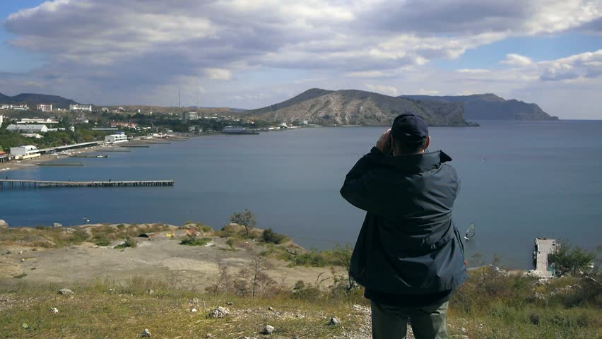 man looking through binoculars on the Bay