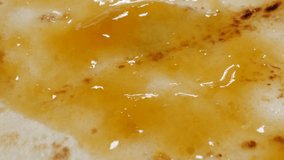 Spreading apricot marmalade topping on sweet dessert surface 4K 2160p 30fps UltraHD tilting footage - Jam of peaches spread with knife over pancake texture close-up 3840X2160 UHD video