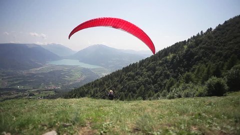 takeoff in the mountains paragliding, spending views of the valley with lake, summer, day, sunny side, Dolada, Italy