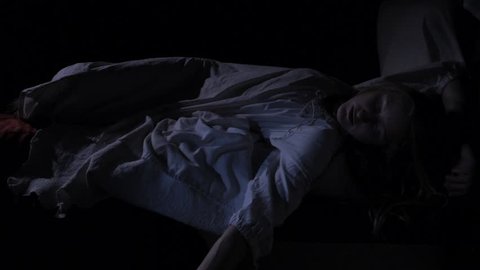 VIRGINIA - SUMMER 2016 - Reenactment, Recreation -- Sleeping woman in dark bedroom of haunted house.  Paranormal, poltergeist.  Woken up and frightened in bed by Ghost / Monster.  Dead Woman in bed.
