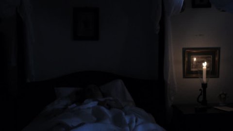 VIRGINIA - SUMMER 2016 - Reenactment, Recreation -- Sleeping woman in dark bedroom of haunted house.  Paranormal, poltergeist.  Woken up and frightened in bed by Ghost / Monster.  Dead Woman in bed.