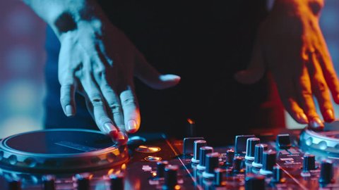 Close up of female hands turning knobs on professional DJ mixer console