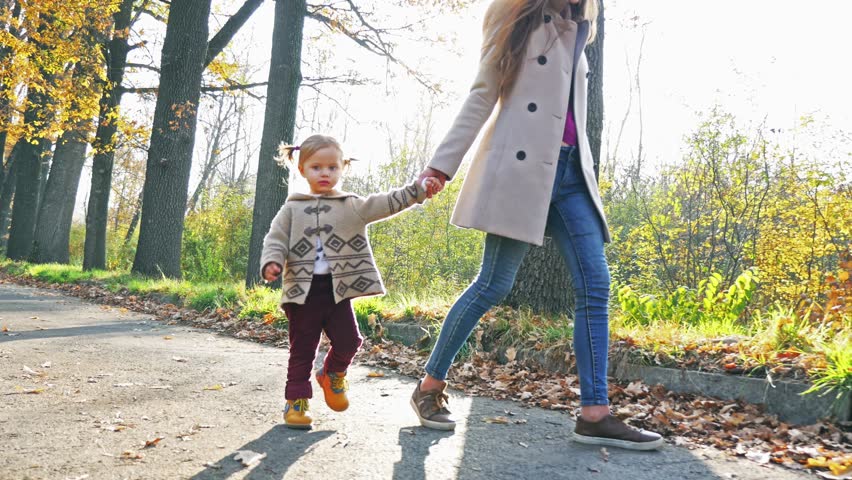 Mother with baby walking outdoor. Autumn