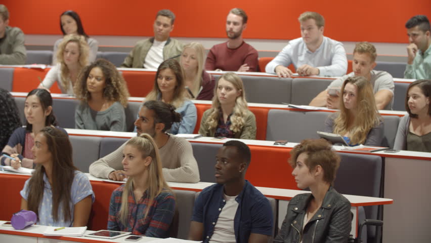 Teacher addressing students in a university lecture theatre
