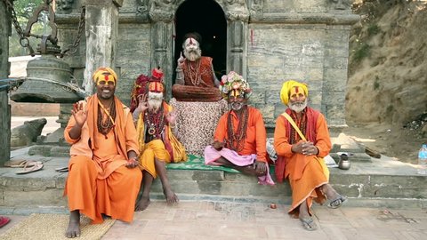 KATHMANDU, NEPAL - APRIL 7, 2016: Group of Sadhus sending greetings to tourist at Pashupatinath Temple. In Hindu religion the Sadhus are holy men.