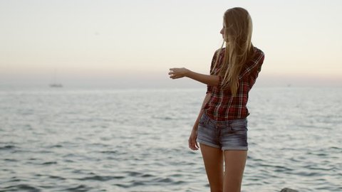 Beautiful young woman posing at a sea background