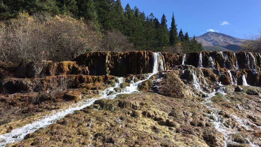 Huanglong Mountain with beautiful nature waterfalls with lime stone  in Sichuan , China on sunny day 