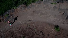 Aerial view of runner from above running along a cliff.