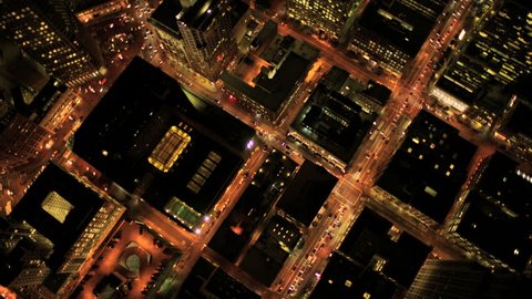Aerial night vertical view of skyscraper rooftops and illuminated streets in a modern city Stockvideo