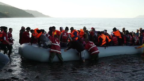 LESVOS, GREECE - NOV 5, 2015: Refugees leave rubber dinghy near the shore.