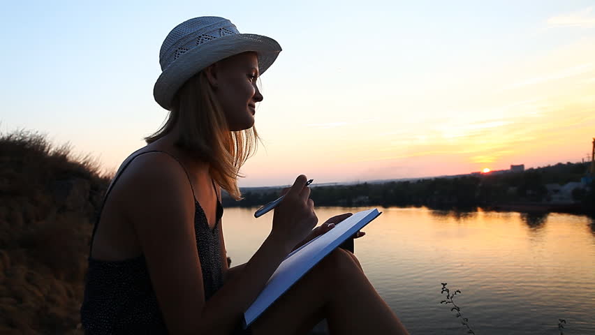 Creative personality with a notebook on the riverside during sunset | Shutterstock HD Video #21300412