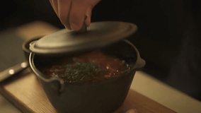 Hand opening clay pot cap with hot steamy kimchi soup
