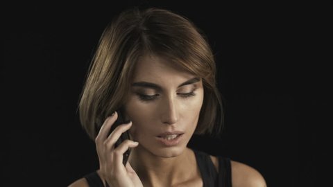 Young depressed upset woman having bad news while talking on the mobile phone 