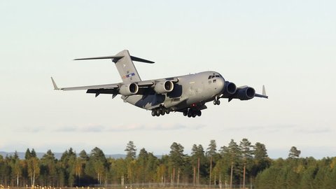 OSLO AIRPORT NORWAY - CA SEPTEMBER 2016: Strategic Airlift Capability Boeing C-17 Globemaster III landing on runway in beautiful evening light slightly slow motion, ambient audio recording