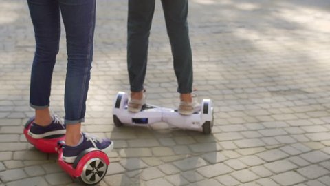 Young man and woman having fun with Hover board in the park. Content technologies. a new movement. Close Up of Dual Wheel Self Balancing Electric Skateboard Smart