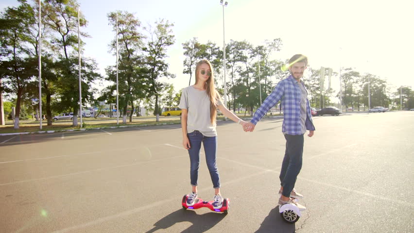 Modern young man and woman walking with Hover board. A new movement. Wide shot. Dual Wheel Self Balancing Electric Skateboard Smart Royalty-Free Stock Footage #21332248