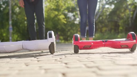 Young man and woman came over to Hover boards and starts ridding. Content technologies. A new movement. Close Up of Dual Wheel Self Balancing Electric Skateboard Smart