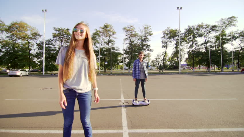 Young man and woman riding on the Hover board. Content technologies. a new movement. Wide shot of Dual Wheel Self Balancing Electric Skateboard Smart Royalty-Free Stock Footage #21332341