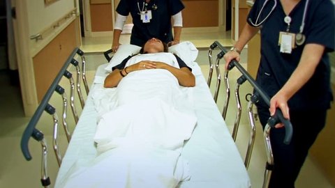 Woman patient on stretcher in a hospital's hallway.