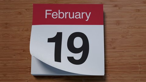 Calendar for February on wooden table flipping through days of month
