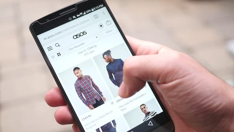 MONTREAL, CANADA - November 2016 : Shopping online on ASOS mobile website on a smartphone. Looking at shirts, pants and other fashion apparels.