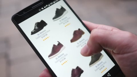 MONTREAL, CANADA - November 2016 : Shopping shoes online on mobile website on a smartphone.