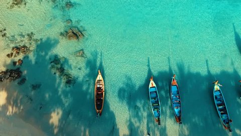 Aerial: Long tail boats on beautiful beach.