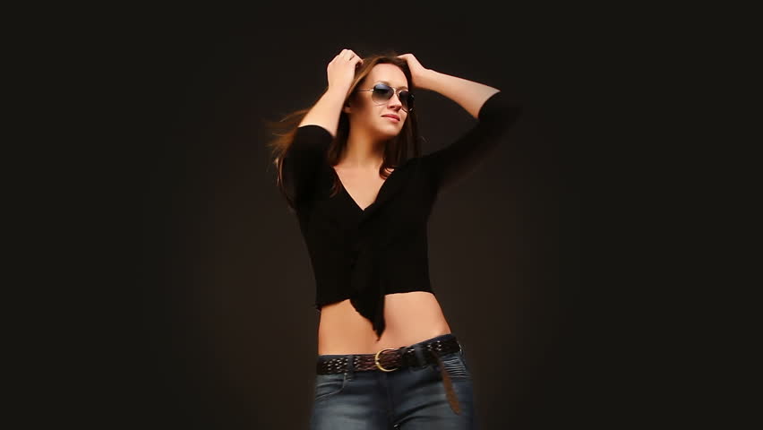 beautiful girl in sunglasses dancing on a black background