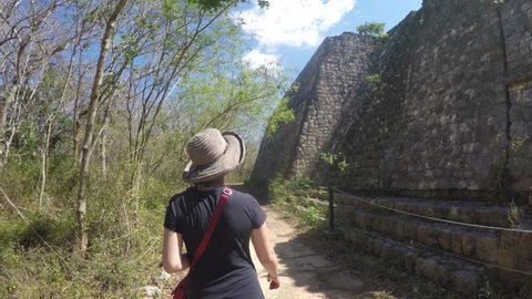 A gimbal shot of tourists walking through the ancient Mayan ruins of Ek Balam near Chichen Itza
