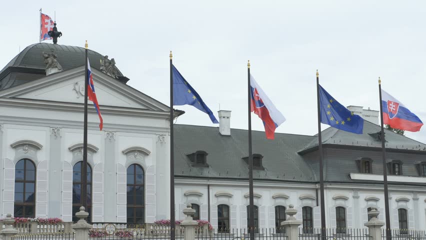 Slovakian and European Union flags waving in the wind in fron of the Grassalkovich Palace in Bratislava.