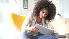 Mixed-race woman websurfing on digital tablet at home