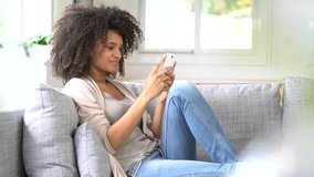 Woman relaxing in sofa and using smartphone