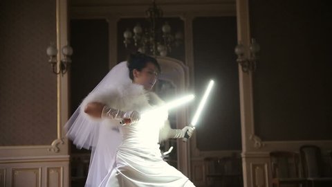 Funny pretty bride playing jedi with lightsaber. Unusual wedding ceremony