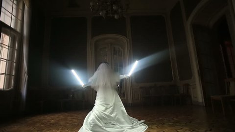 Funny joyful bride playing with lightsaber. 