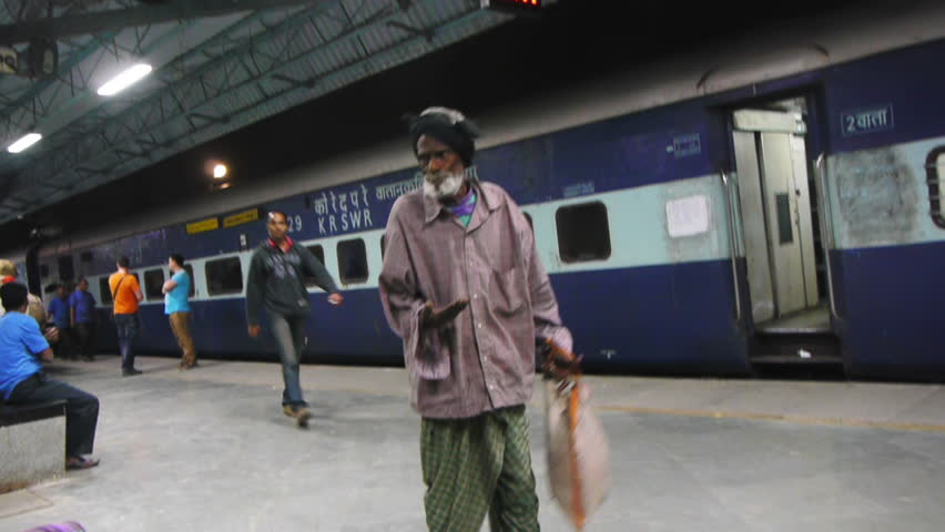 MUMBAI, INDIA - FEB 1: Old man begs and men move baskets at a railway station February 1, 2012 on Chhatrapati Shivaji Terminus (formerly Victoria Terminus) Mumbai, India. | Shutterstock HD Video #2141009