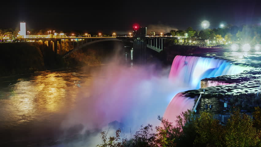 Night Show Niagara Falls. Tourists on a viewing platform to admire the illuminated waterfall