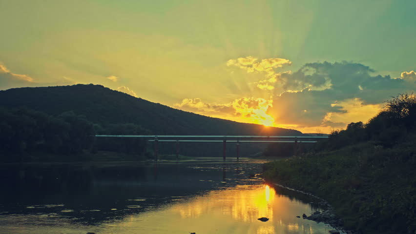 The pipeline over the river in the background a beautiful sunset.