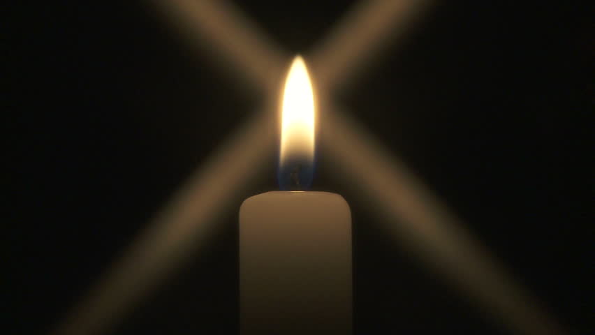 Close up of single candle burning in the dark