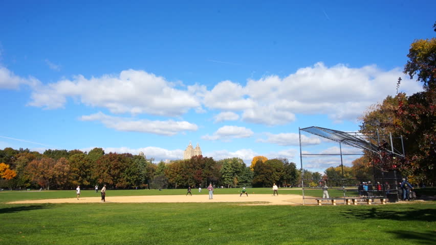 Baseball players in Central Park, New York City. Wider shot.
