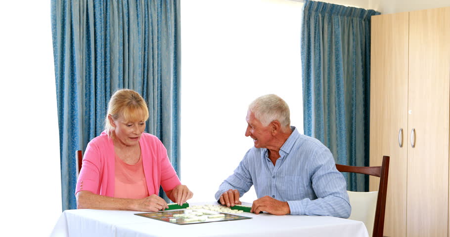 Senior Caucasian couple playing puzzle at home