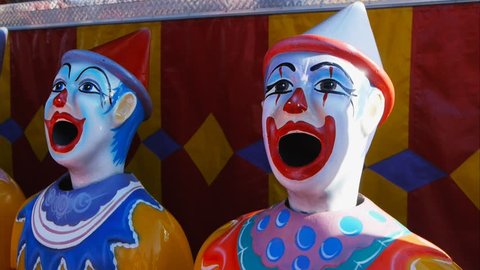 a county fair game with rotating clown heads