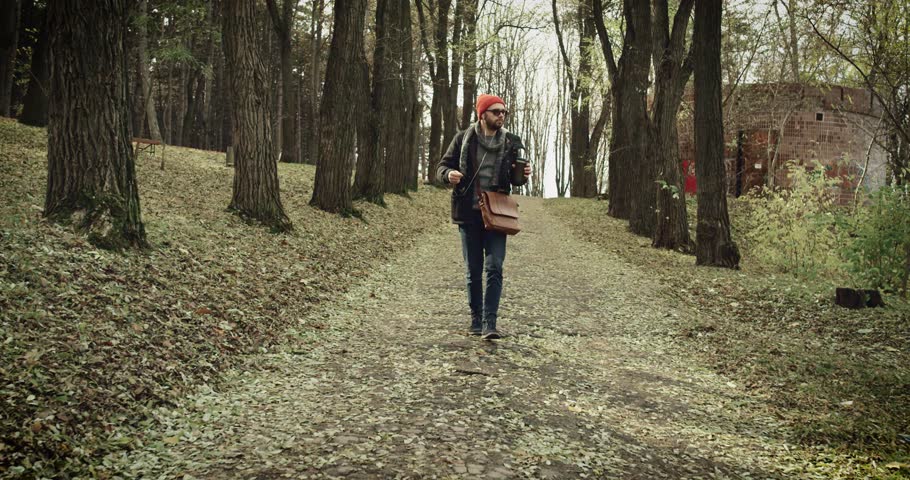 Bussinesman  dancing and listening to music in park in autumn day 4k